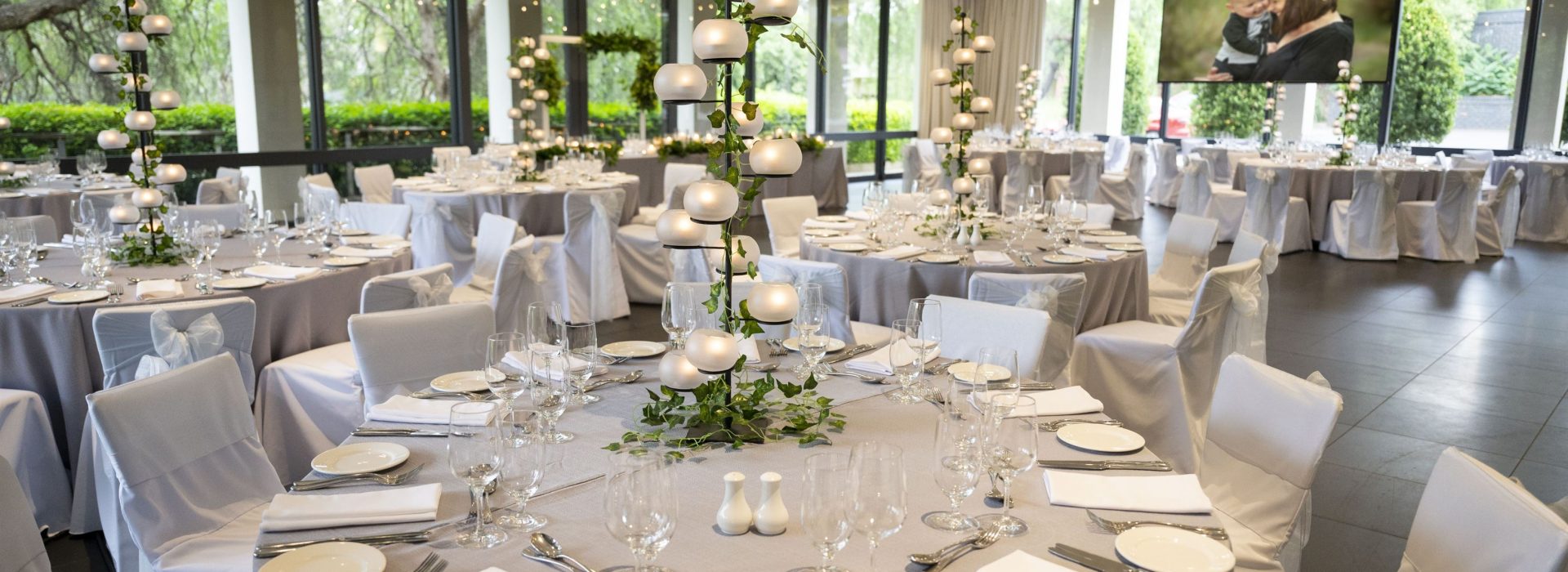 Elegant wedding reception room in Melbourne with grey linens and stunning large windows.